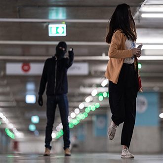 Jeune femme fuyant son agresseur dans un parking